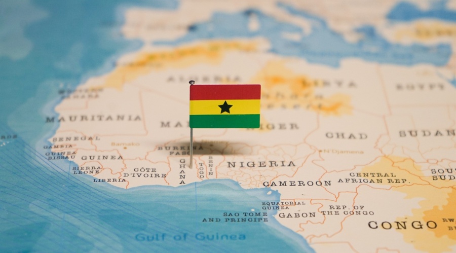 A flag of Ghana on a map pointing at the country