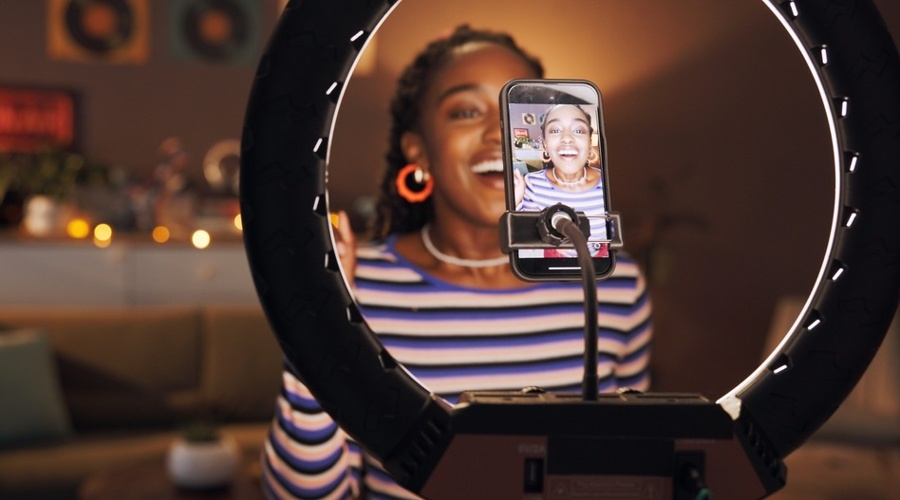 Black woman, influencer and phone with ring light at house for post