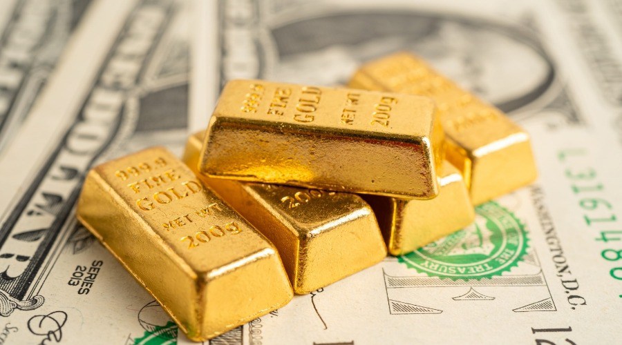 Gold trading concept: small gold bars lying on US dollar bills