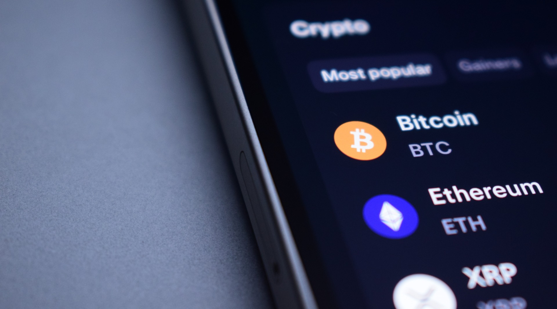 Lista de tokens Bitcoin, Ethereum y XRP mostrados en la pantalla de un smartphone