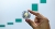 Ethereum token holded in two fingers with a upward green chart in the background, shutterstock