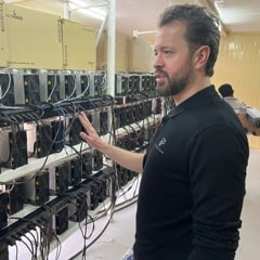 Pantheon Mining CEO Lodewyck Berghuijs in front of a rack of Bitcoin mining machines.