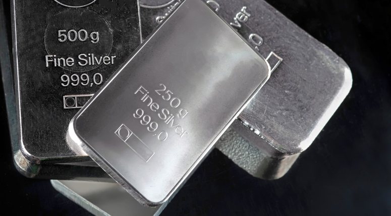 Several silver bars of various weights on a dark background