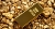 Gold bar laying on gold nuggets.