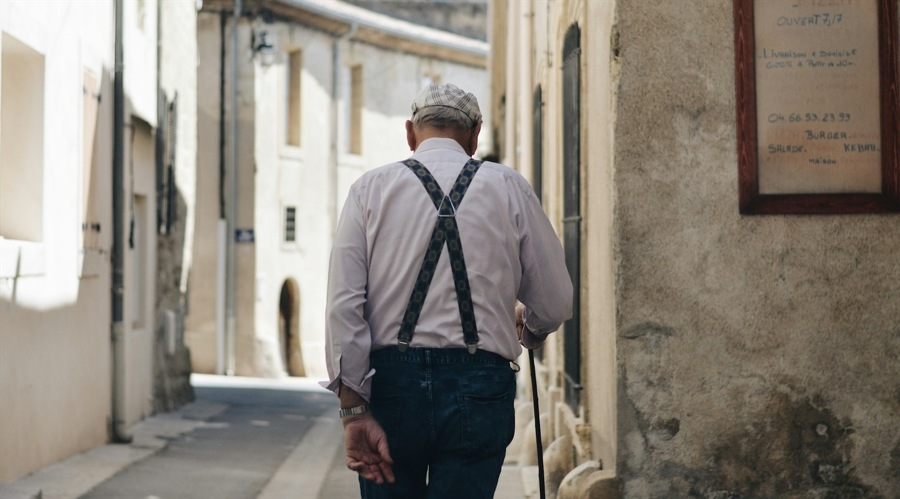 The back of the old man walking in the street