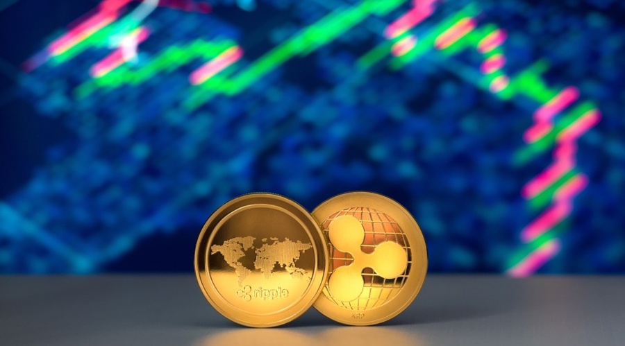 Two xrp tokens standing in the front of candle chart